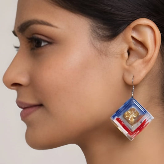 Close-up of a woman wearing a colorful earring with a neutral background